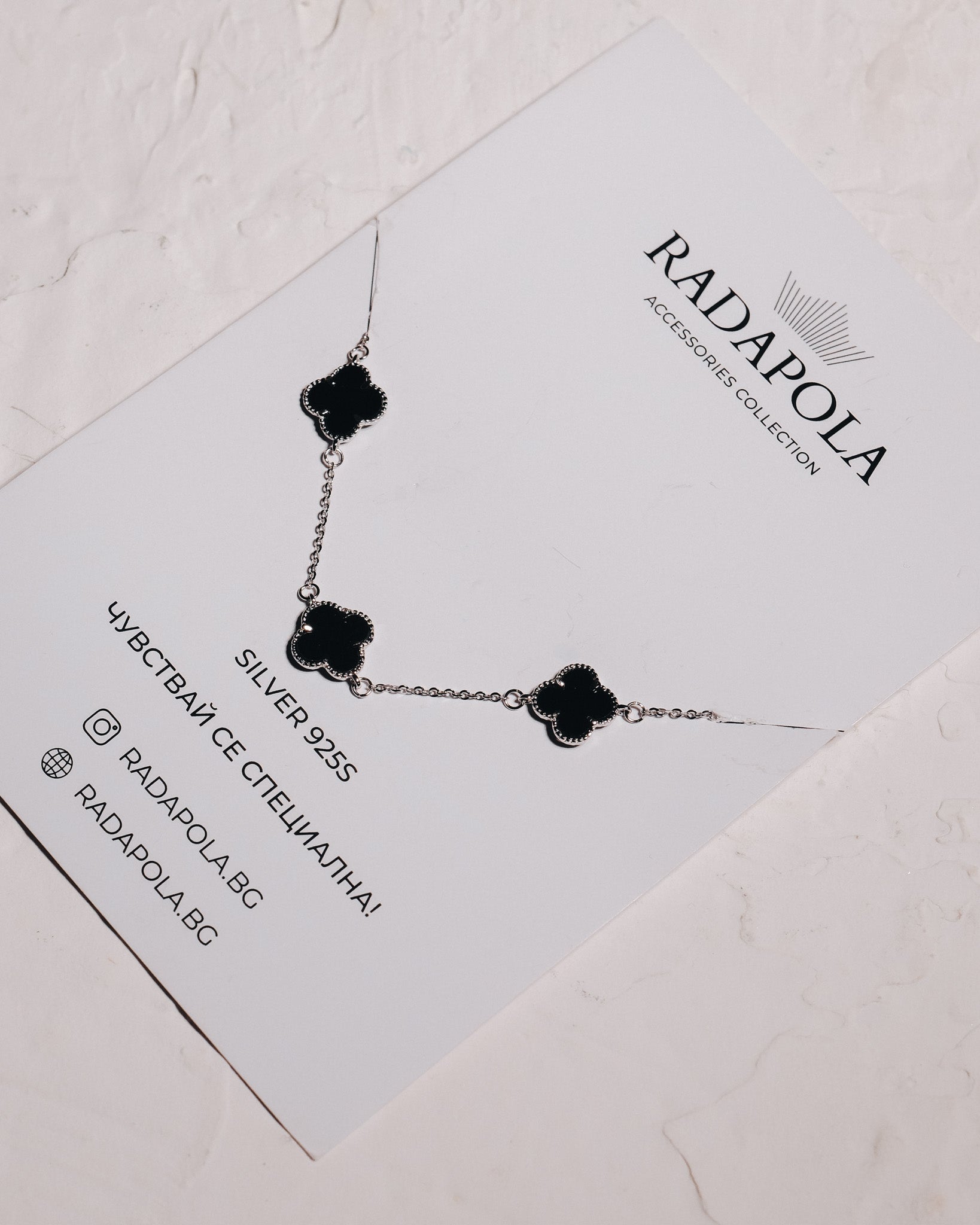 Silver bracelet with black clovers